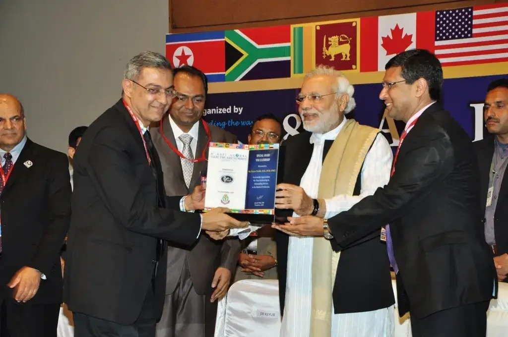 Group of men posing with large cartoon character inflatable figures at night outdoors