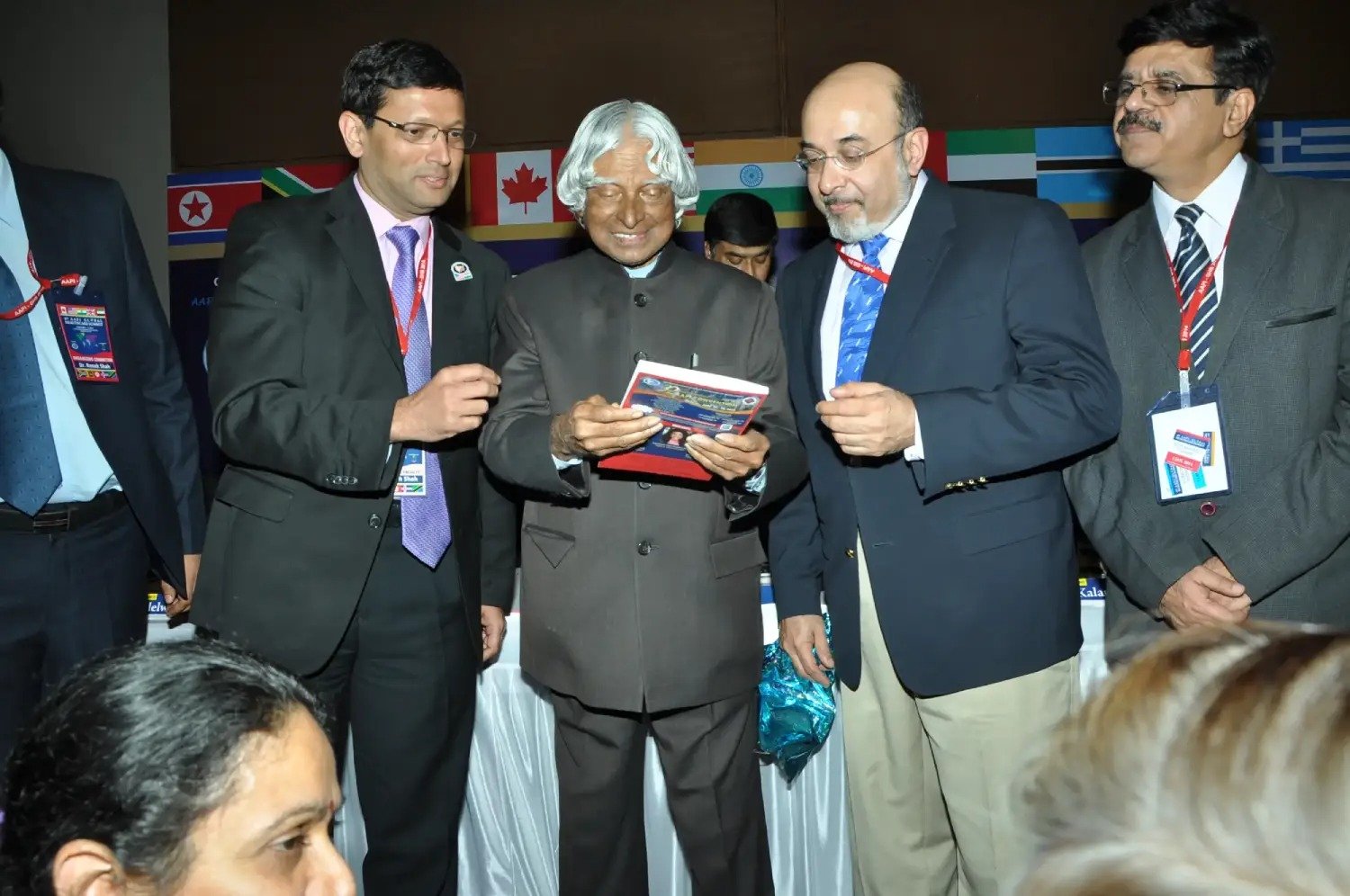 Musical performance on stage with three performers and ITT banner in background