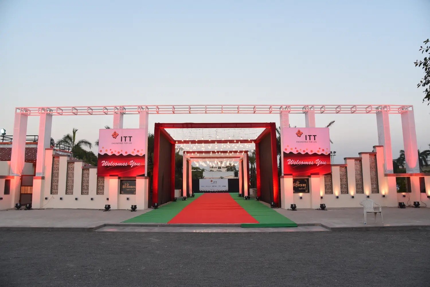Annual Day event venue with red carpet and white pillars under blue sky