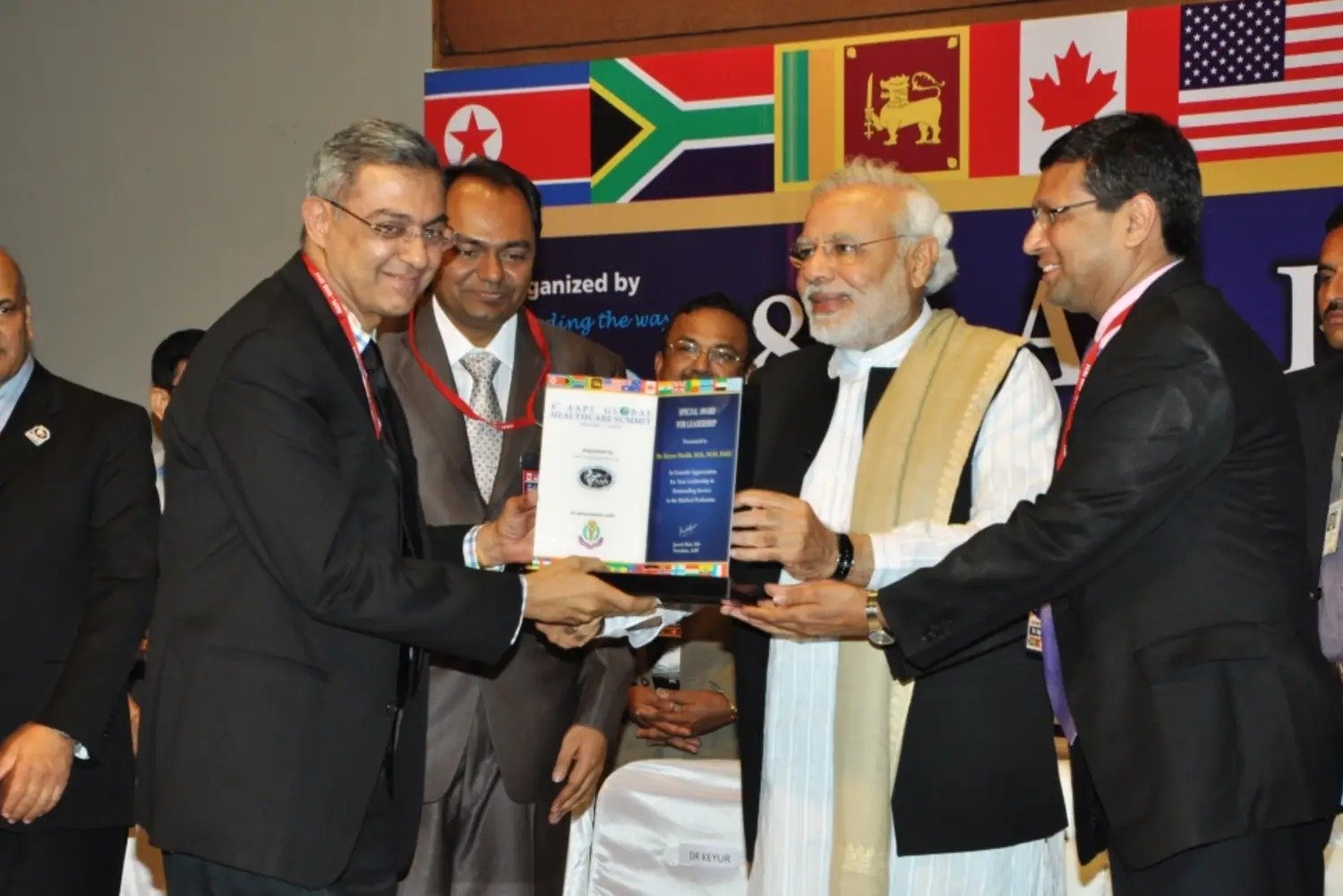 Conferences with people presenting awards and flags in background