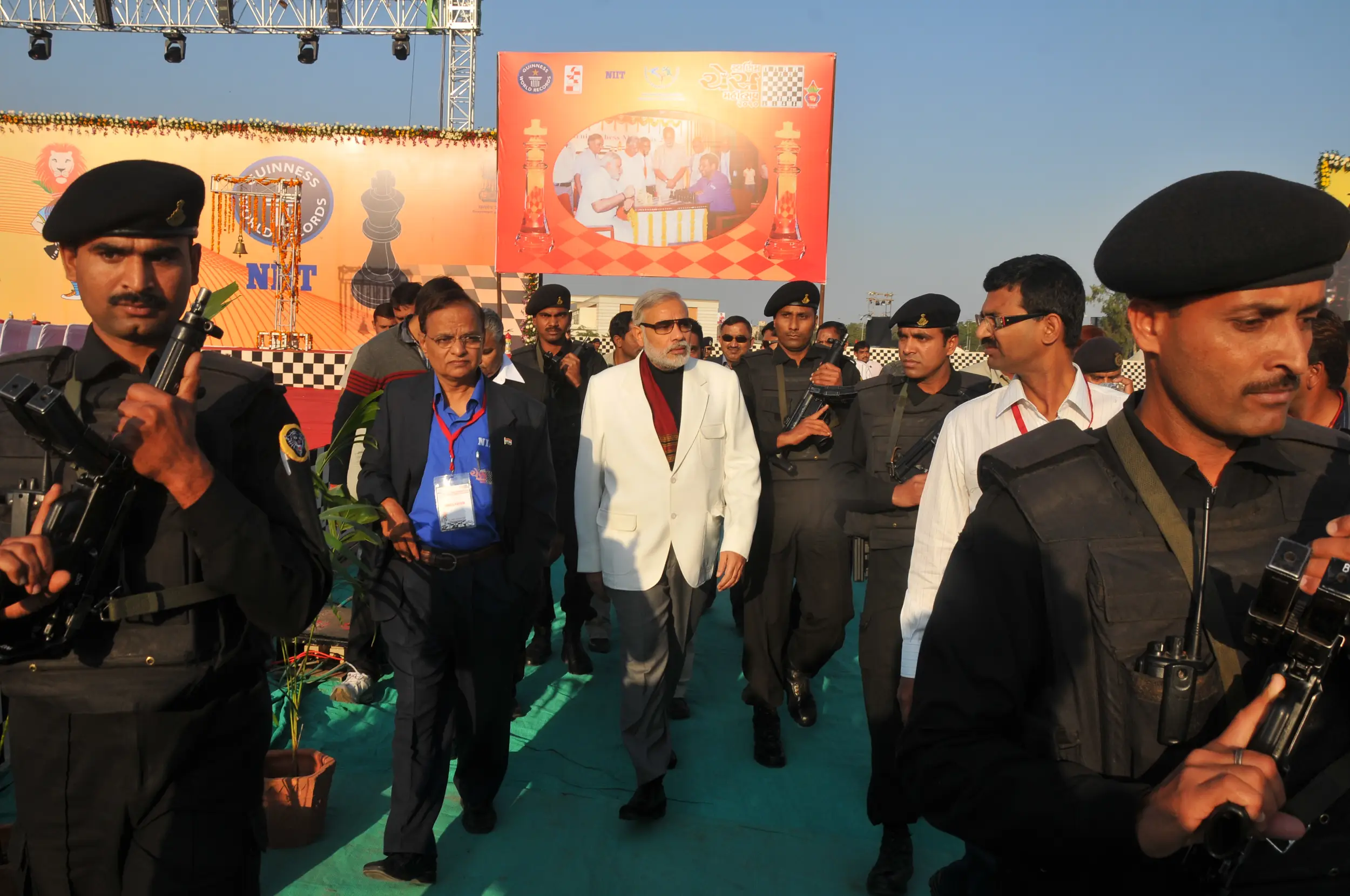 Men lighting ceremonial lamp at event with ITT banner in background