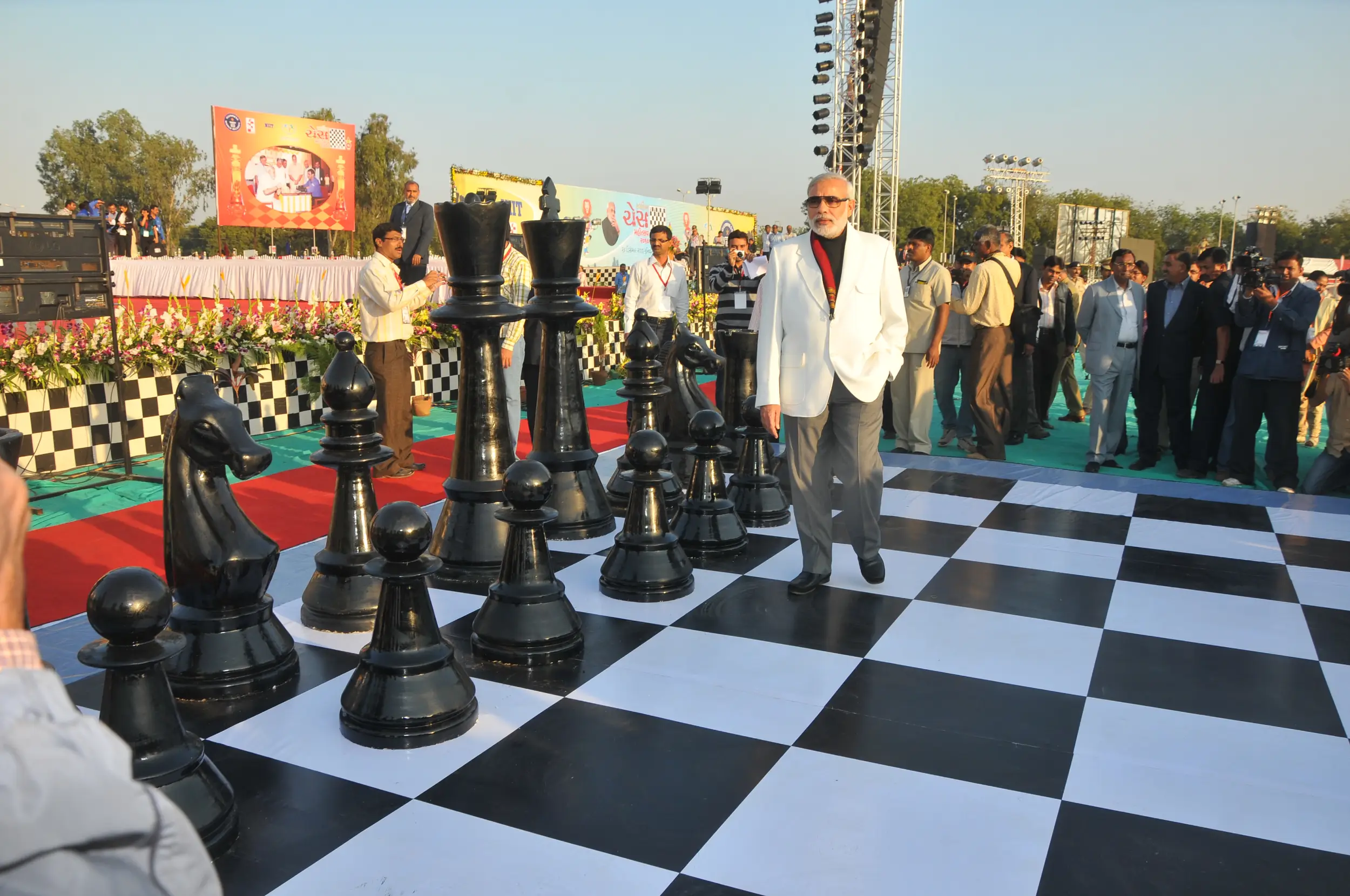 Men lighting ceremonial lamp at event with ITT banner in background