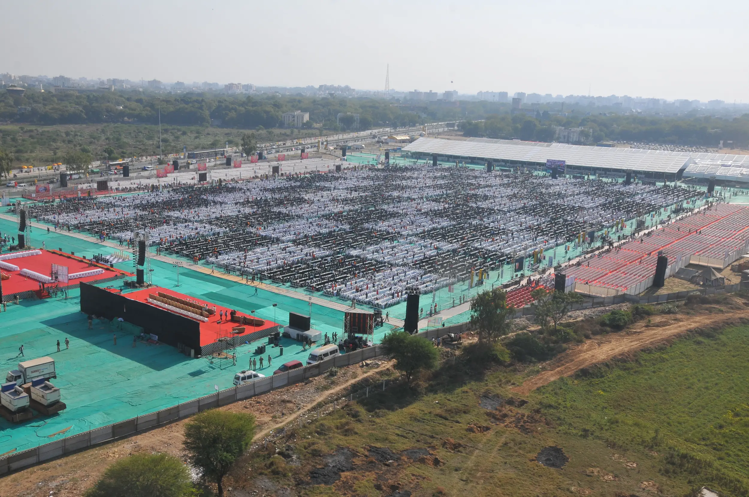 Men lighting ceremonial lamp at event with ITT banner in background