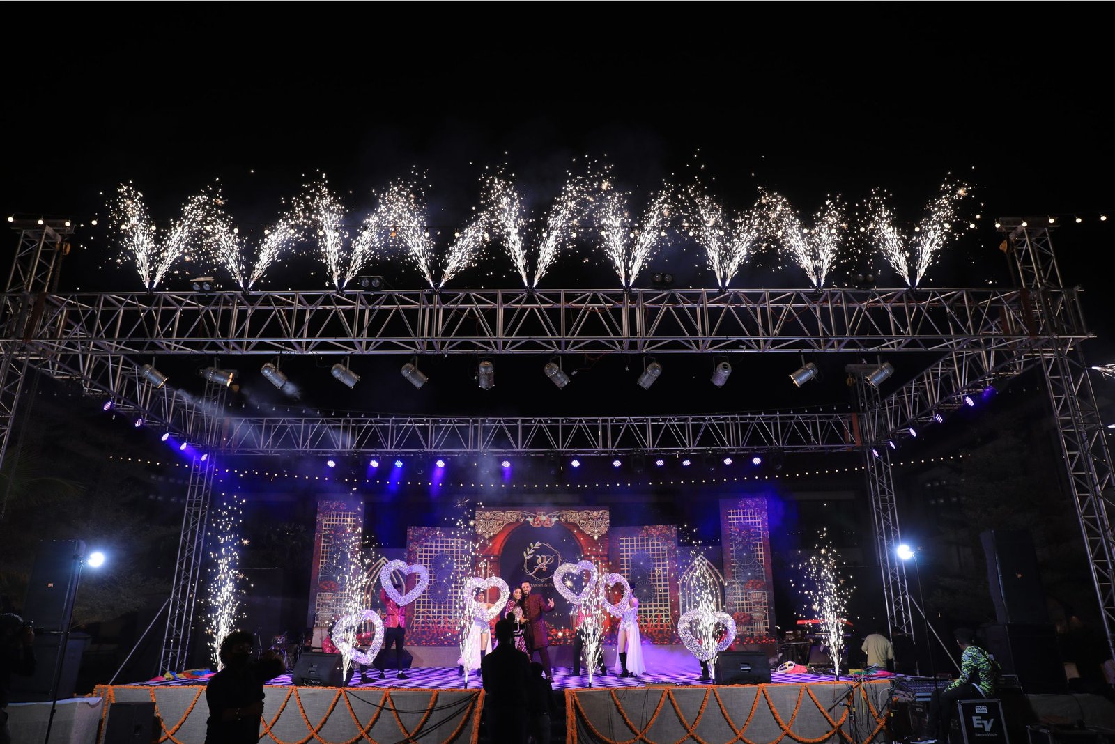 Group of men posing with large cartoon character inflatable figures at night outdoors