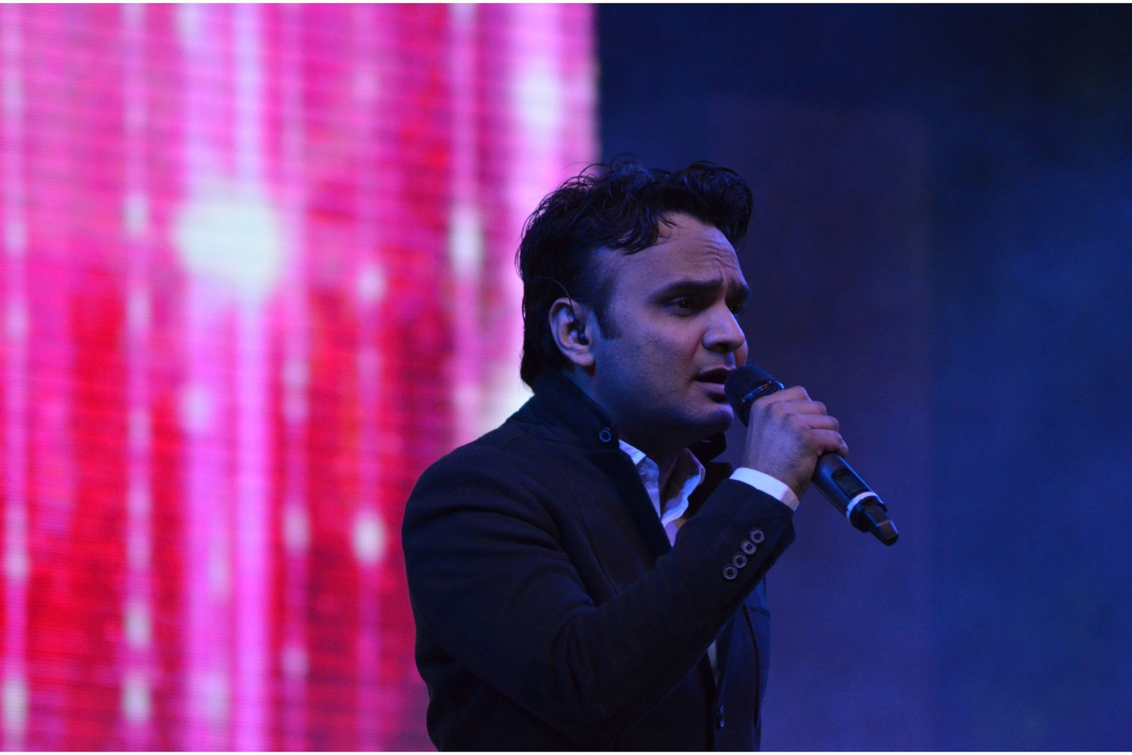 Balloon arch in orange, black, and white colors framing an ITT logo board lit with warm lights