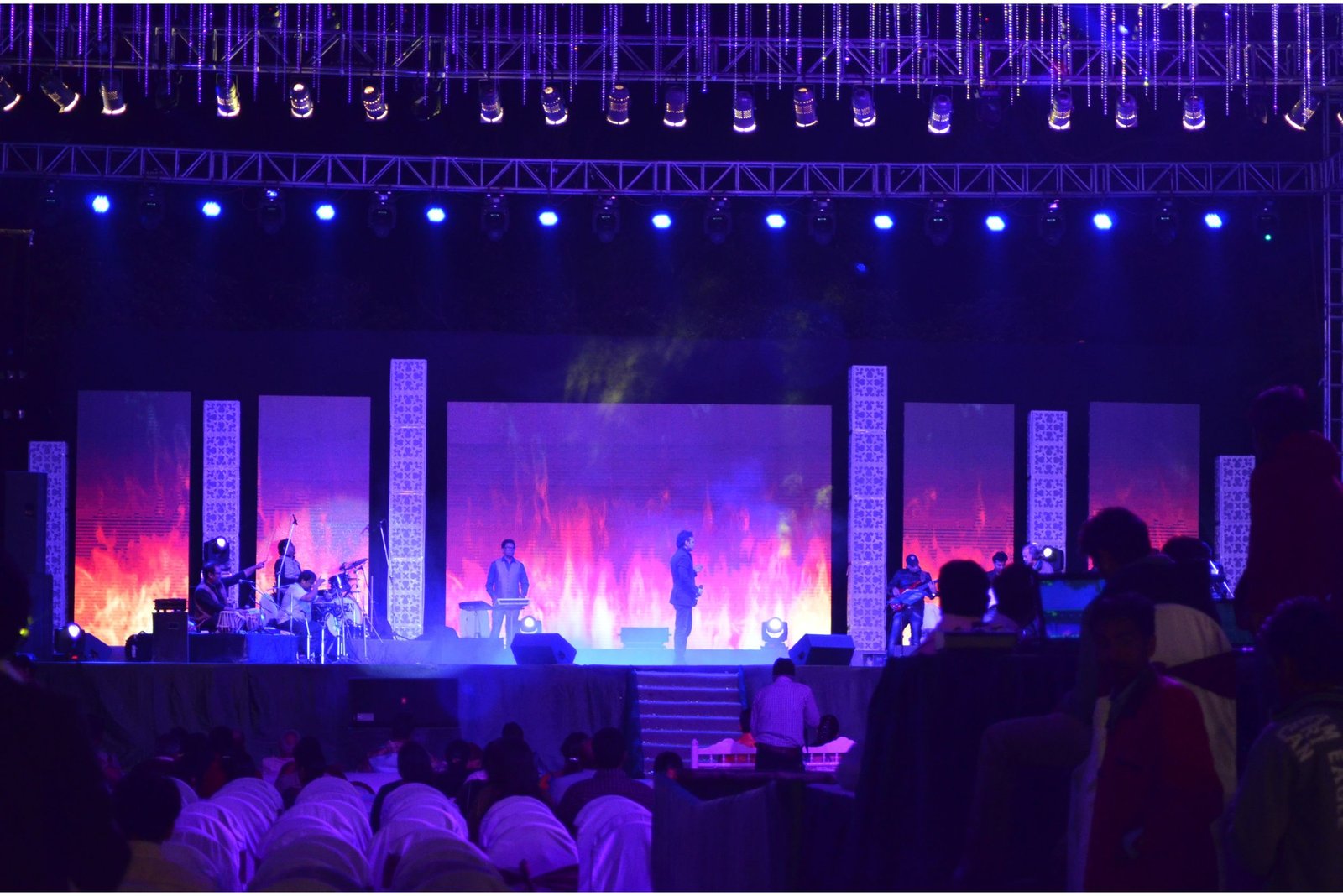 Group of men posing with large cartoon character inflatable figures at night outdoors