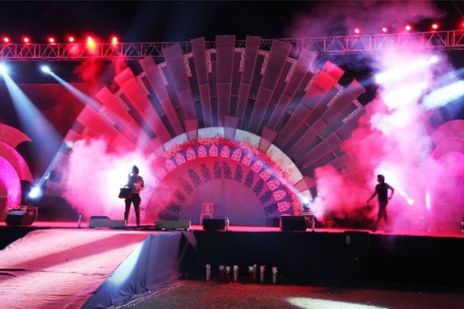 Men lighting ceremonial lamp at event with ITT banner in background